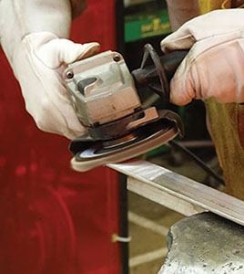 Worker using a Weiler grinding disc